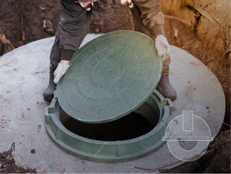 The plumber covers the sewer well with a manhole cover. Water supply and sewerage in a residential building