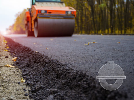 Road roller flattening new asphalt. Heavy vibration roller at work paving asphalt, road repairing.