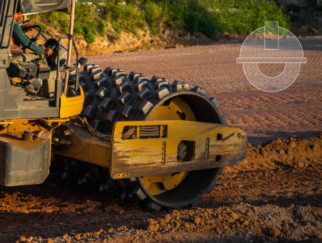 Soil compactor with vibratory padfoot drum. Heavy duty machinery working on highway construction site. Vehicle for soil compaction. Road construction equipment. Paving. Compaction of the road.