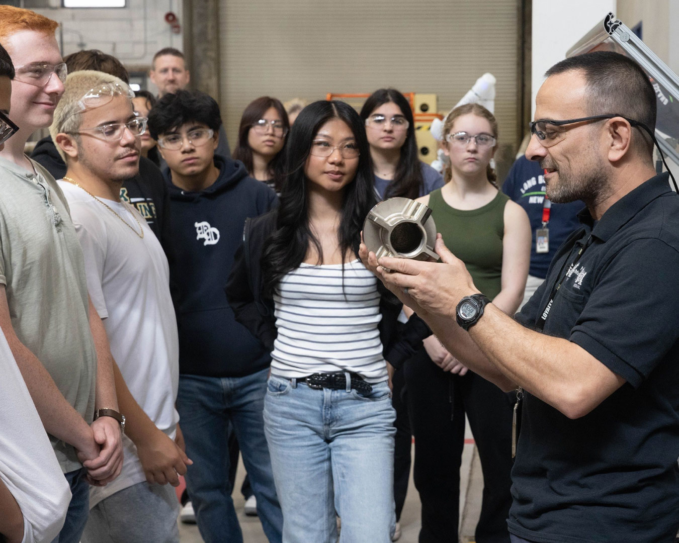 While Nick Loewrigkeit, UTRS Program Manager, Prototype Manufacturing looks on, Branch Chief Frank Petrosillo describes manufacturing processes and explains equipment used to prototype armament hardware. (U.S. Army photo by Todd Mozes)
