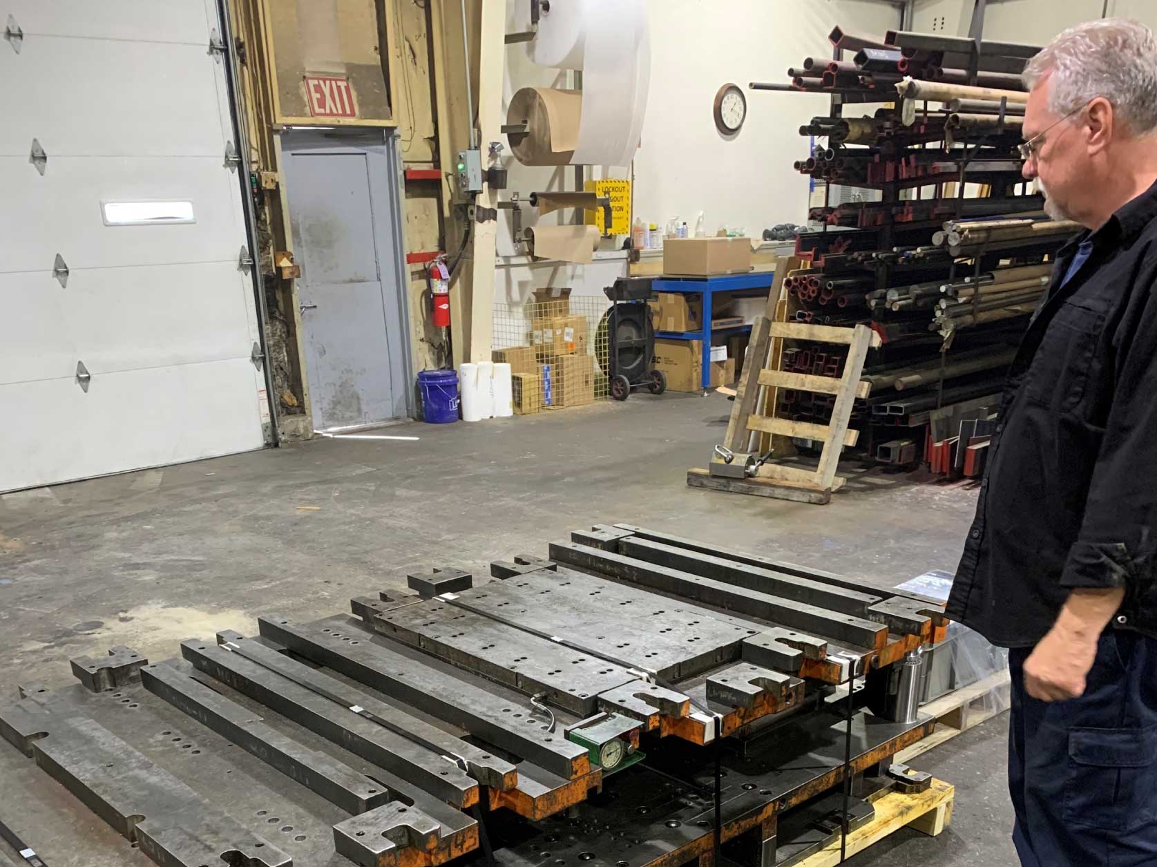 The repaired progressive die set composed of plates, each 4-ft wide by 8-ft long by 2-inches thick and weighing about 3,000 pounds
