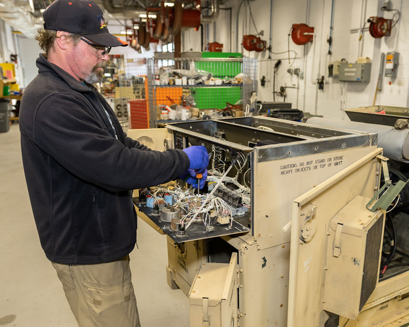 Photo of employee working on a generator. Image source: https://www.tobyhanna.army.mil/Capabilities/Integration-Support-Services/Integration/