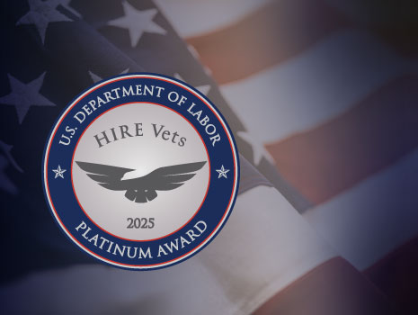U.S. Department of Labor HIRE Vets Platinum Award Medallion over image of American flag.