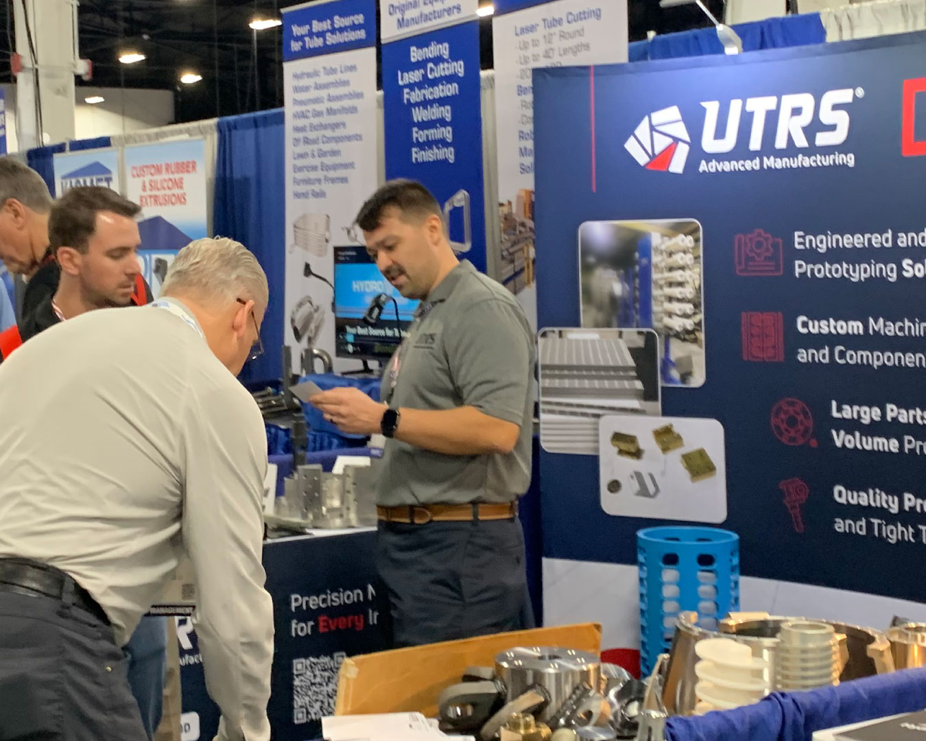 UTRS AM employees at the Design-2-Part trade show in Oaks, PA talking with trade show attendee