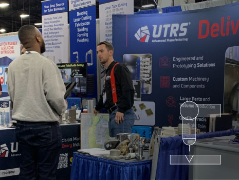 UTRS AM employee at the Design-2-Part trade show in Oaks, PA talking with trade show attendee