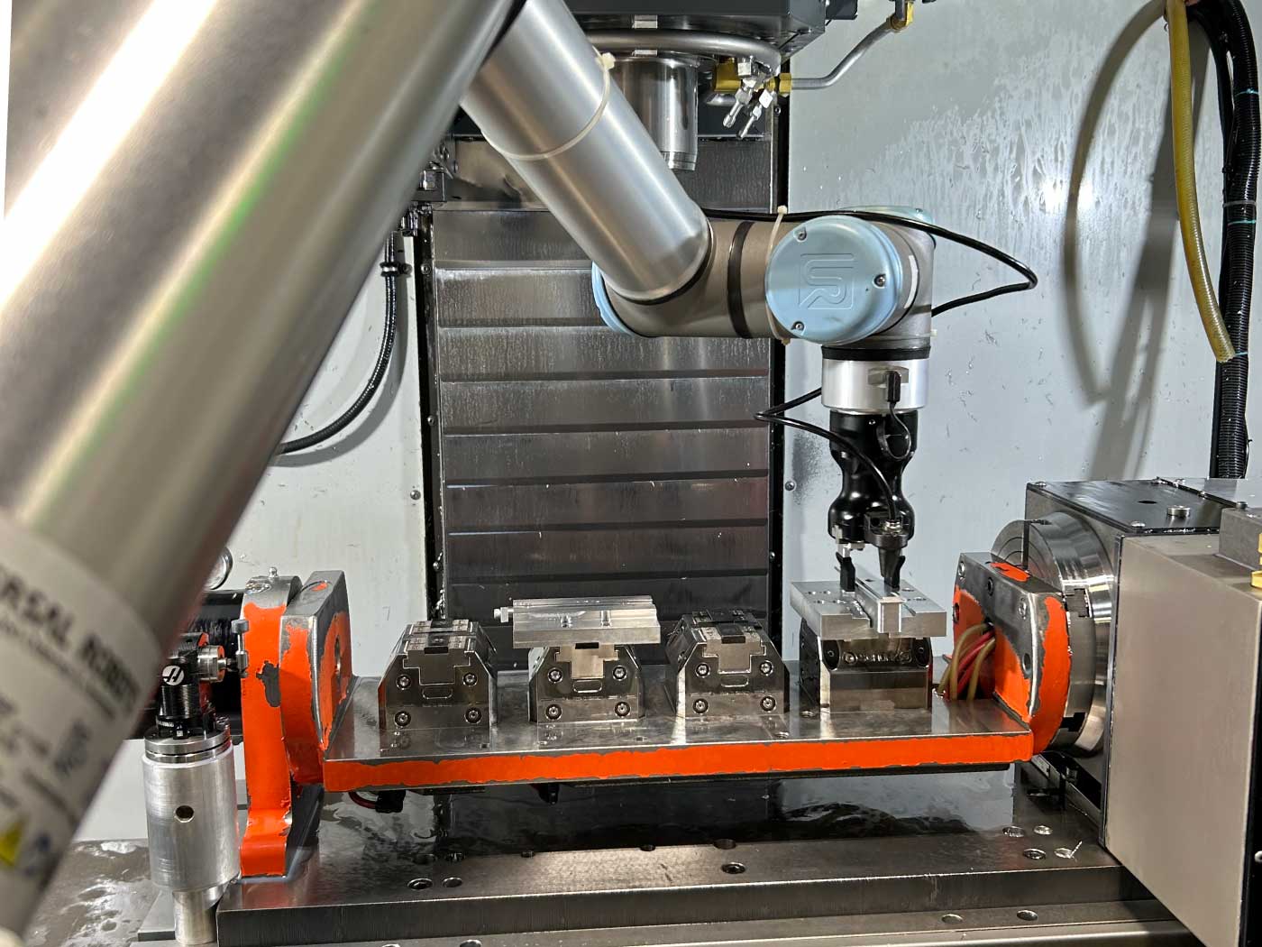 Robotic arm removing a machined component