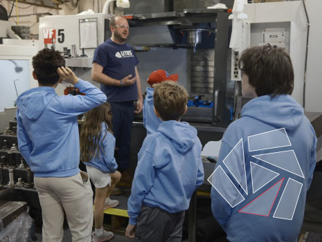 Children learning from a UTRS Advanced Manufacturing machinist how CNC machines operate.