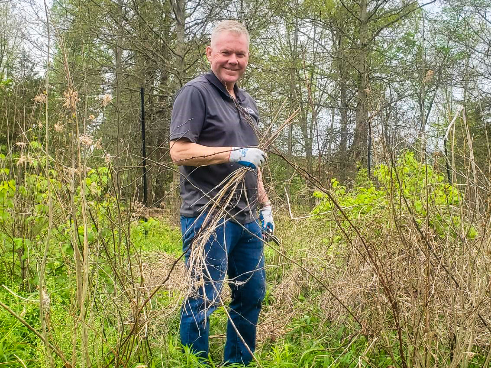 UTRS volunteer removing invasive plant species and clearing old plant debris