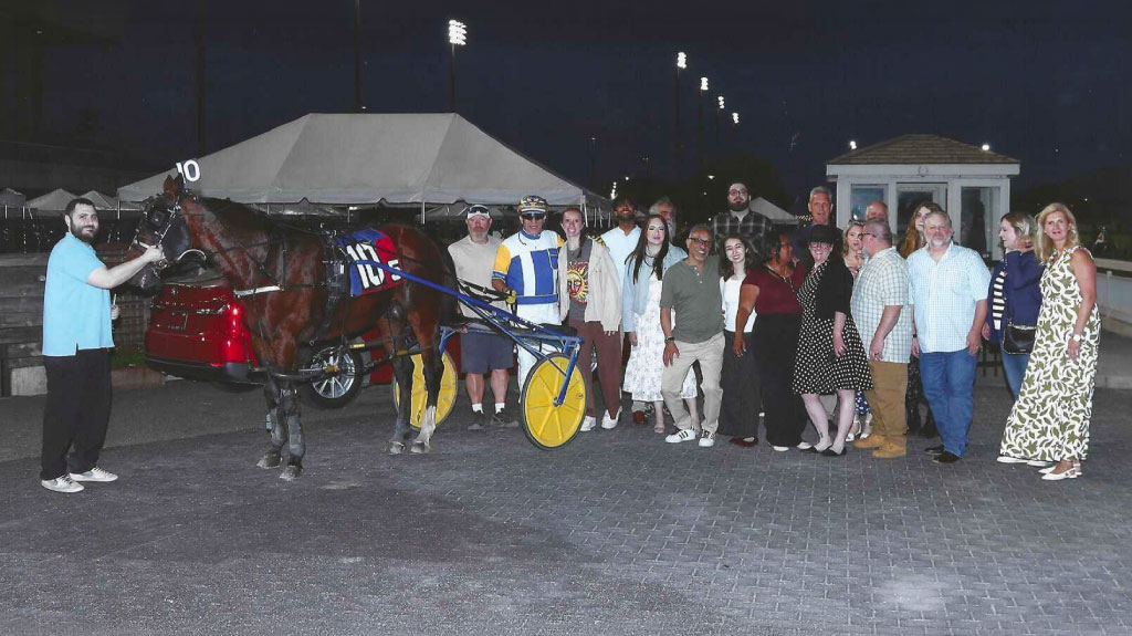 Group photo of UTRS employees at the annual Night at the Races with horse and rider