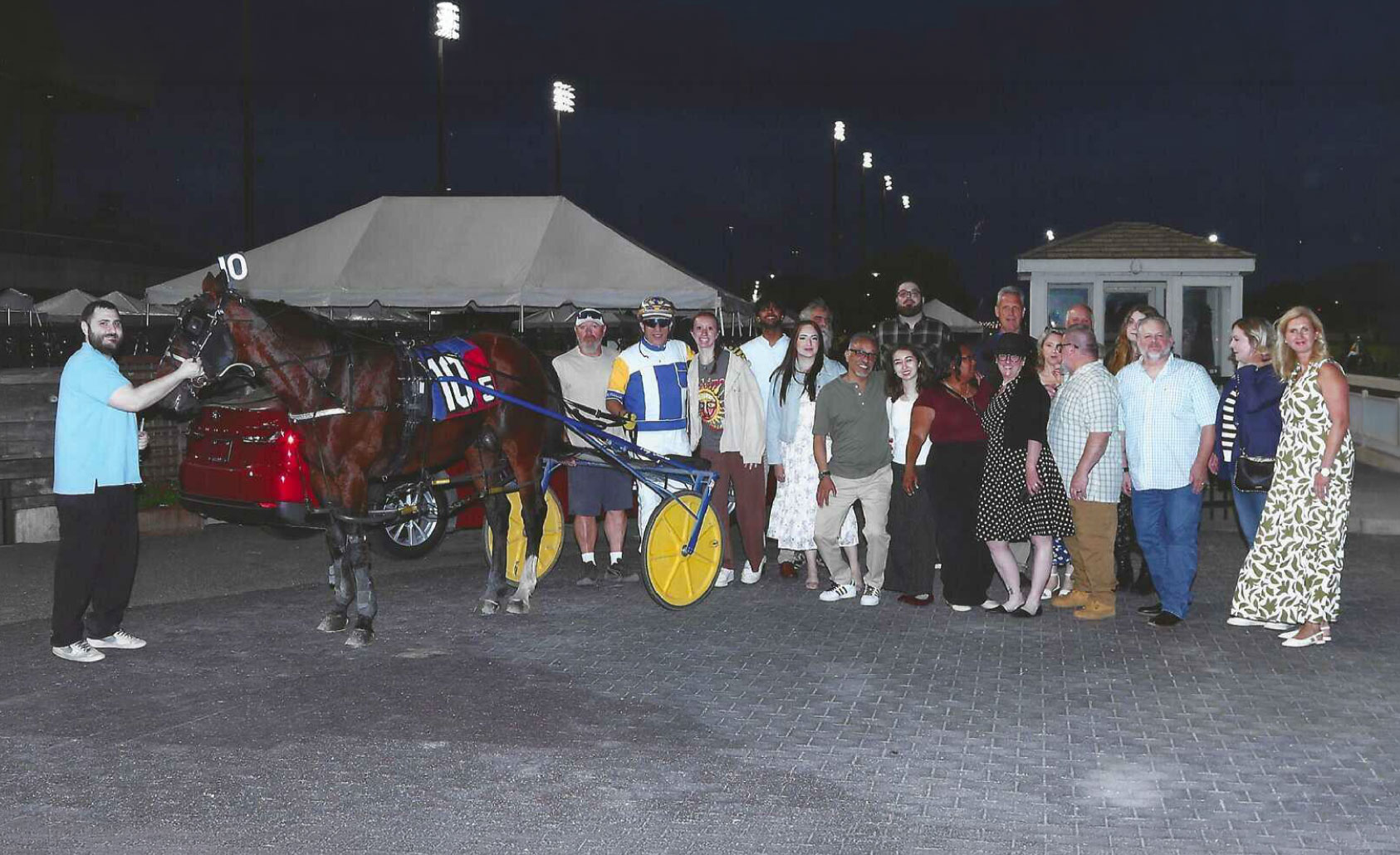 Group photo of UTRS employees at the annual Night at the Races with horse and rider