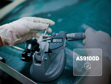 Image of quality control during manufacturing. AS9100D logo is overlaid on image with UTRS shield icon in bottom right.